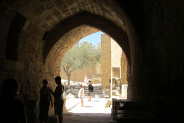 Noch durch den Tunnel über dem die byzantinische Kirche liegt die zur Zeit Restauriert wird aus der Zeit der Johanniter bei der Besichtigung von dem Akropolis Berg von Lindos und der Insel Rhodos beim Griechenland Urlaub und schon befinden wir uns im Heiligtum der Akropolis.