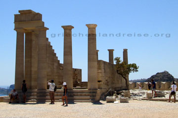 Touristen bei der Besichtigung von dem Athena Tempel auf der Akropolis von Lindos und der Insel Rhodos beim Griechenland Urlaub.